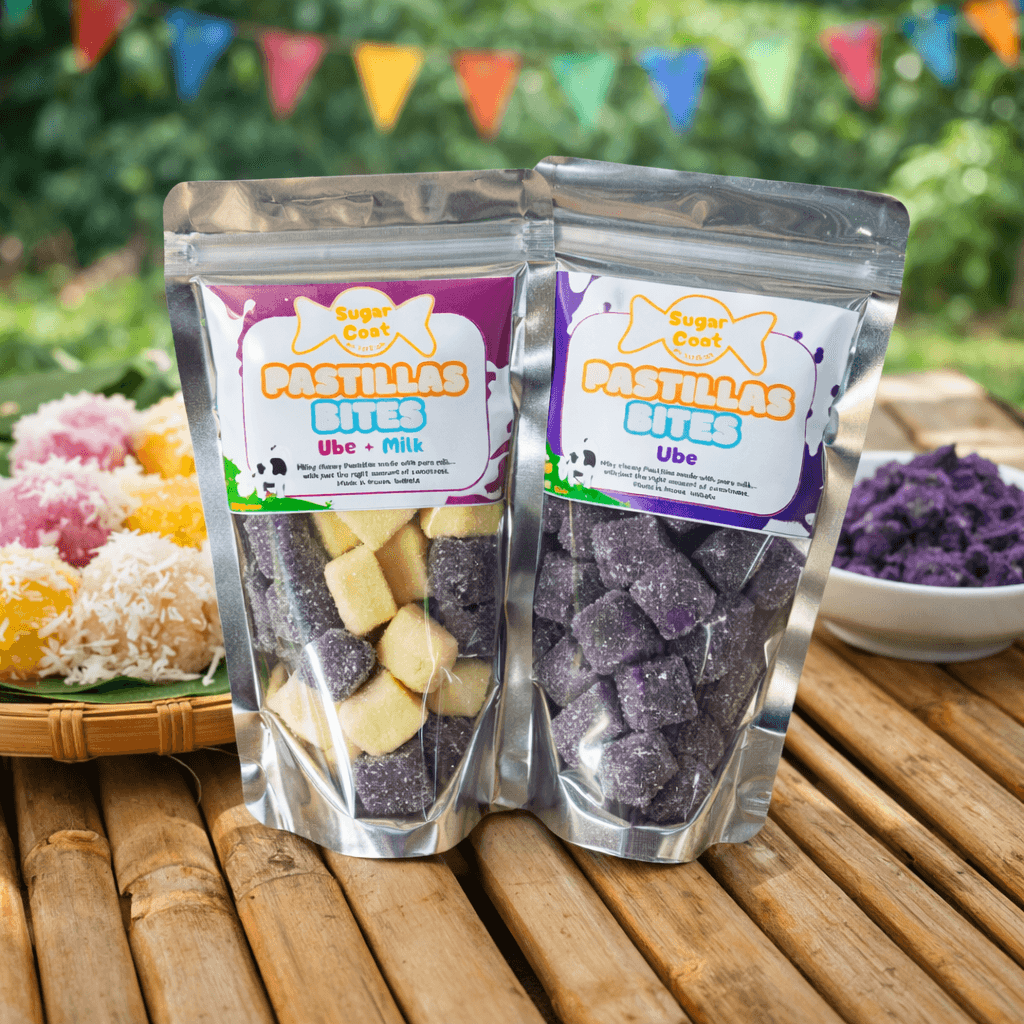 Two pouches of Ube and Milk Pastillas Bites on a bamboo table with colorful desserts.